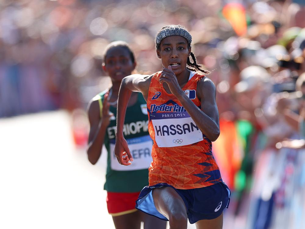 Sifan Hassan of the Netherlands stays ahead of Ethiopia's Tigst Assefa at the finish of the women's marathon on Sunday at the Paris Olympics. Hassan won gold, adding to two bronzes she won in the 5,000 and 10,000 meter races.