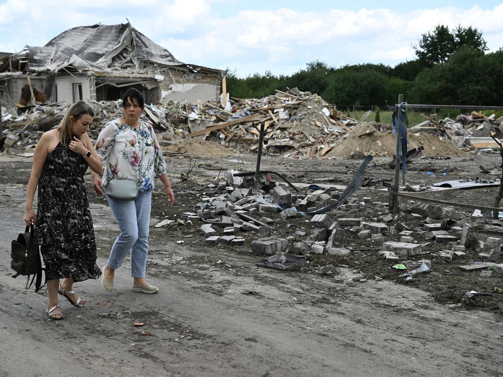 Local residents walk past a residential house, heavily damaged following a Russian missile strike on Sunday, in a village in the Brovary district, Kyiv region, amid the Russian invasion of Ukraine. Fragments of a missile fell on residential buildings in Brovary district, near Kyiv, the State Emergency Service of Ukraine said on Telegram. 