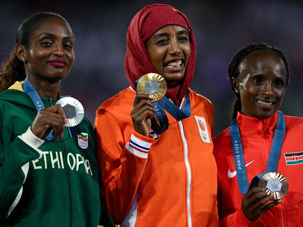Silver medal winner, Ethiopia's Tigst Assefa, gold medalist Netherlands' Sifan Hassan and bronze medalist Kenya's Hellen Obiri pose during the podium ceremony for the women's marathon event on Sunday.