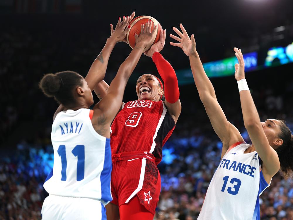 A'Ja Wilson #9 of Team United States shoots between Valeriane Ayayi (L) and Janelle Salaun of Team France during the Women's Gold Medal game Sunday at the Paris Olympics.
