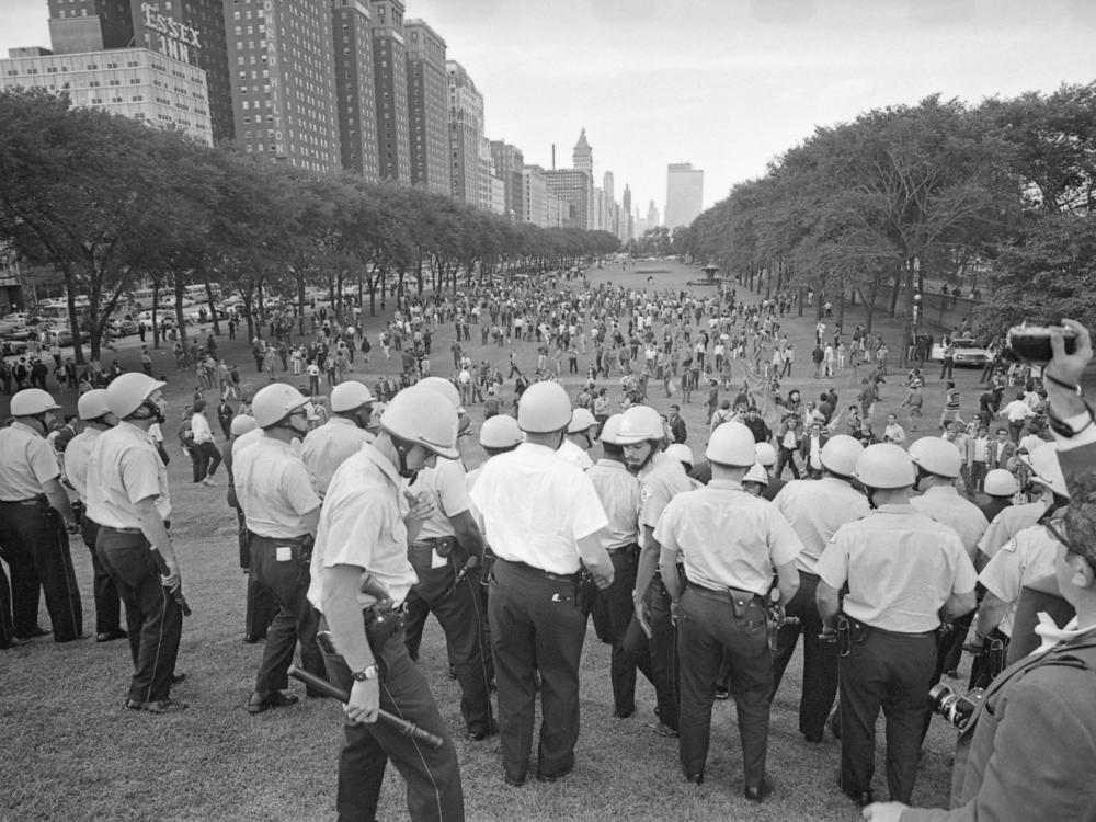 General view of police lined up and holding batons in Grant Park trying to control the crowd with protesters during the 1968 Democratic National Convention in Chicago, Illinois, August 1968.
