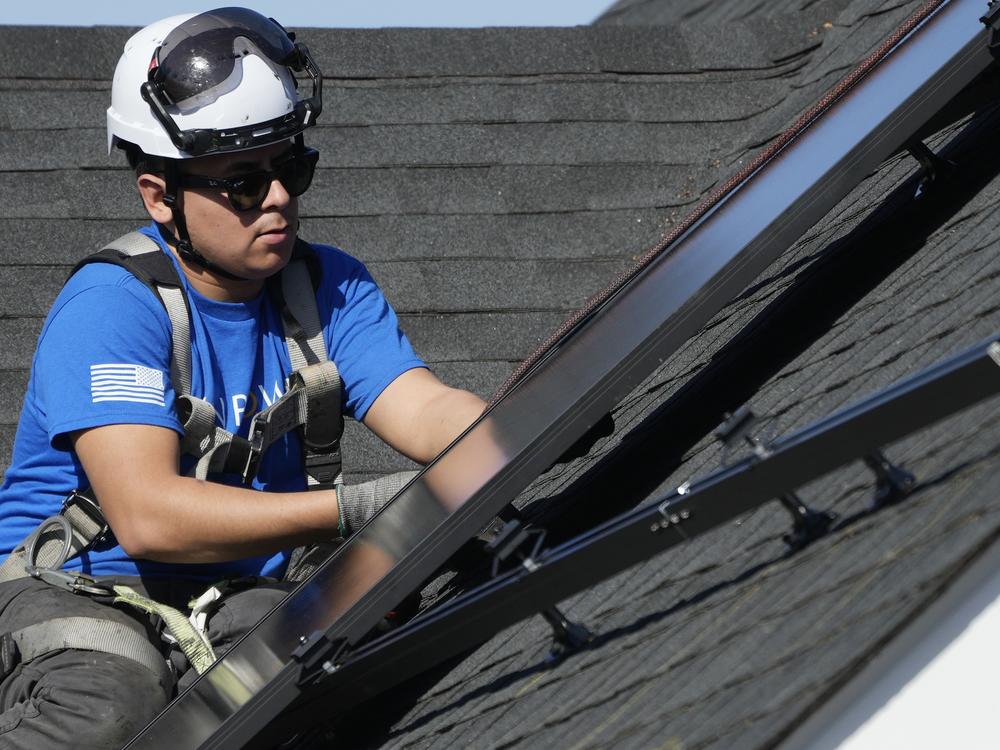 A technician installs solar panels on a home roof in Arlington Heights, Ill., earlier this year.