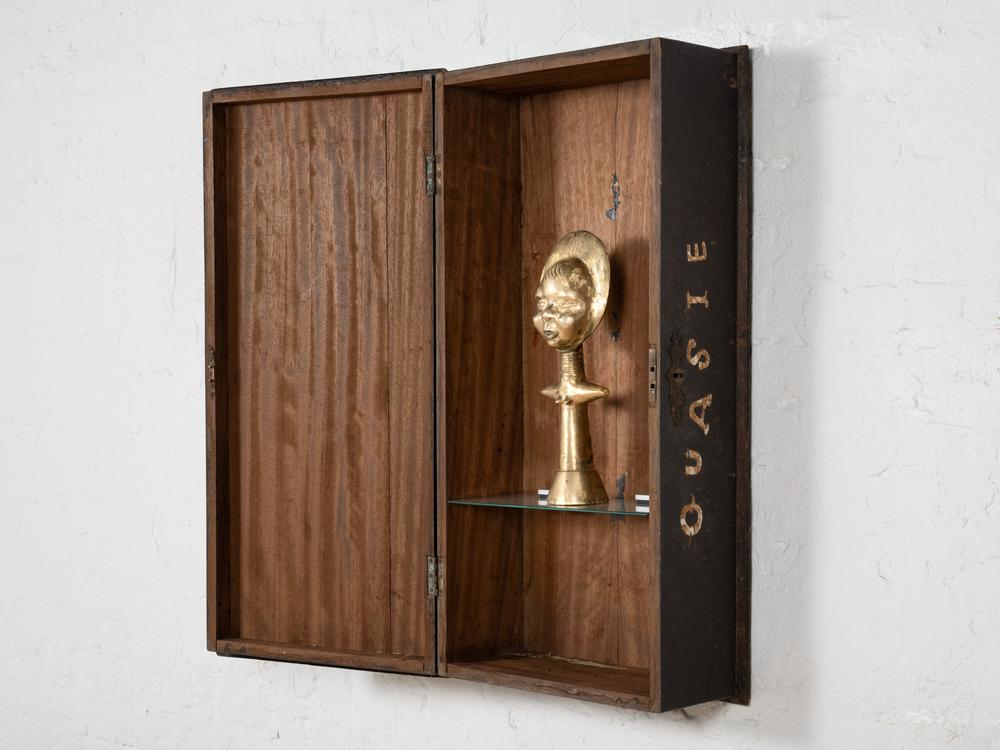 The wooden chests used by the British during their colonial rule of Ghana are turned into trophy cases displaying the country's famed statuary.