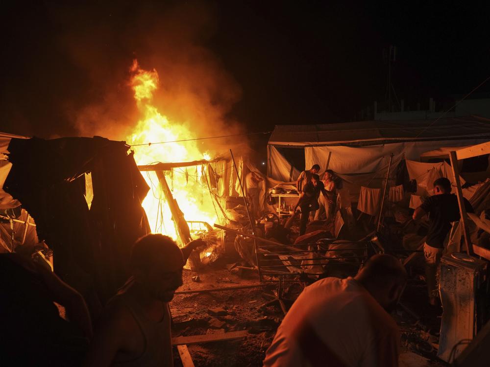 Palestinians react to fire from an Israeli strike that hit a tent area in the courtyard of Al Aqsa Martyrs hospital in Deir al Balah, Gaza Strip, on Sunday. The strike killed several people including a woman and injured others, health officials confirmed.
