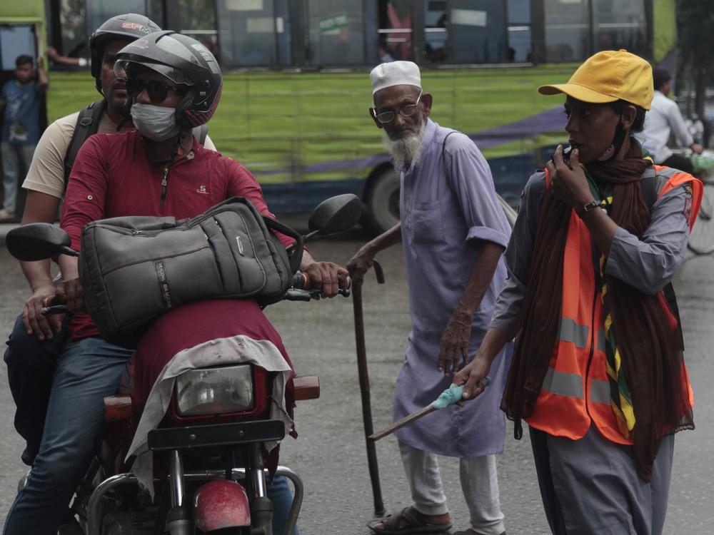 Shahana Akhtar, 26, directs traffic at a busy intersection in Dhaka, wearing her scout uniform to project authority. Akhtar supported the students’ movement to oust Bangladesh's former prime minister Sheikh Hasina, and hopes the new interim government will create more jobs. She says she’s never had a paid job.