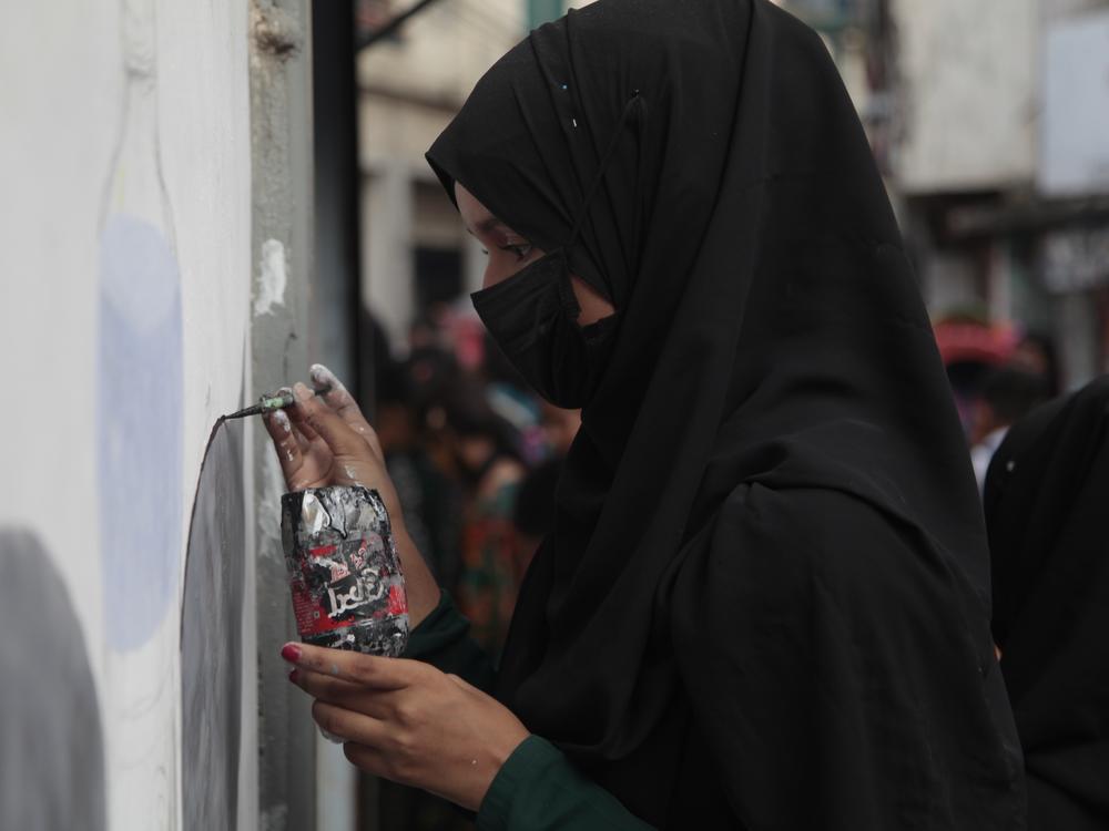 High school students paint a mural on their school wall in a crammed alleyway in the Bangladeshi capital Dhaka. Across the city, young people are painting murals on walls to celebrate what they call the Generation-Z revolution, the student movement that  toppled the former prime minister Sheikh Hasina.