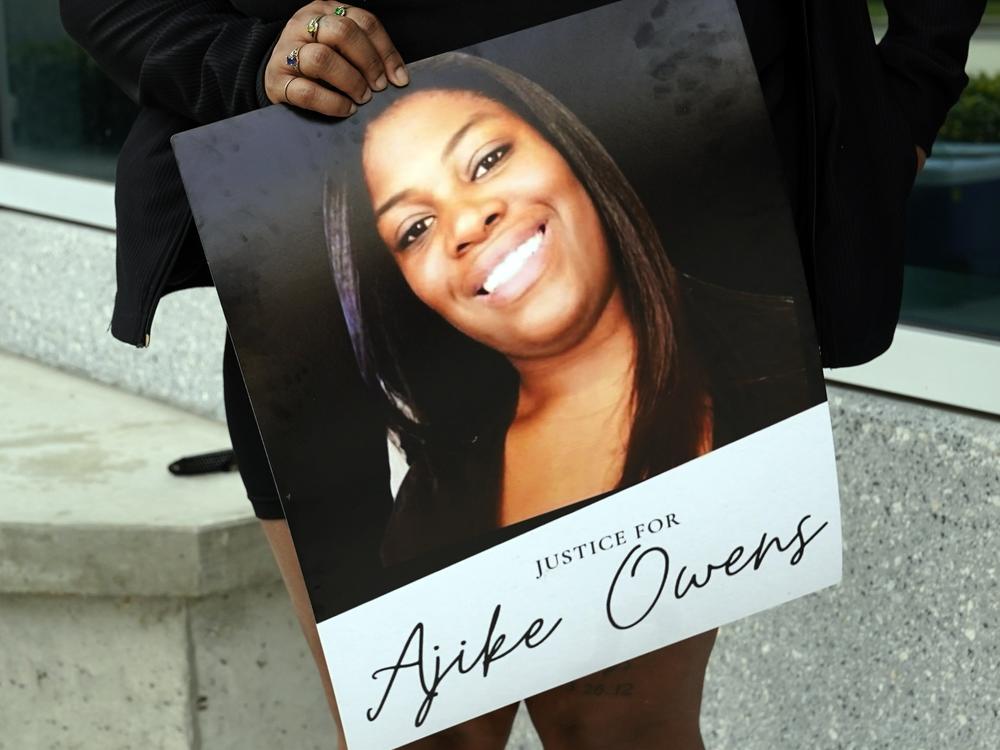 A protester holds a poster of Ajike Owens and demands the arrest of a woman who killed her during a rally at the Marion County Courthouse, June 6, 2023, in Ocala, Fla.