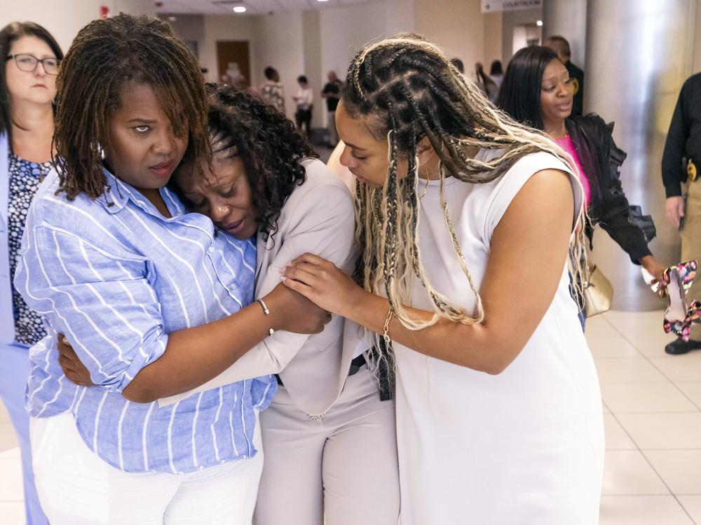 Pamela Dias (center), Ajike “A.J.” Owens' mother, is consoled by friends and family outside the courtroom after a jury found Susan Lorincz guilty of manslaughter in the shooting death of her daughter, Friday afternoon in Ocala, Fla. 