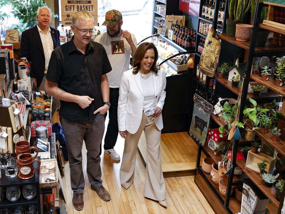 Vice President Harris talks with store owner Nick Meyer while campaigning with Minnesota Gov. Tim Walz and singer Justin Vernon of Bon Iver in Eau Claire, Wis., on Aug. 7, 2024.