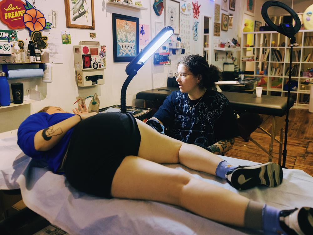 Ella Sklaw talks through the process with their client, Maddie Dennis-Yates.
