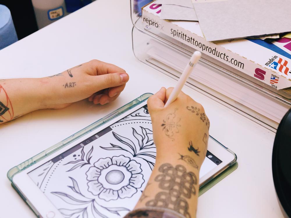 Monde puts together a tattoo design.