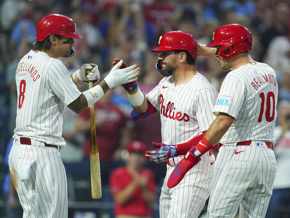 Kyle Schwarber, center, celebrates his grand slam with Nick Castellanos, left, and J.T. Realmuto against the Miami Marlins on Aug. 14, 2024.