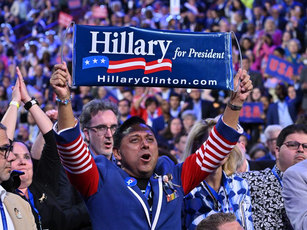 An attendee holds a 2016 banner 