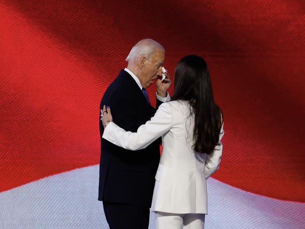 Joe Biden wipes away a tear on stage.