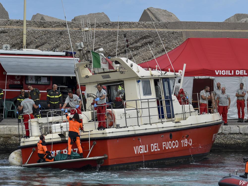 Italian firefighter divers bring ashore in a green bag the body of one of the victims of the U.K.-flag vessel Bayesian on Wednesday. The luxury sail yacht was hit by a violent sudden storm and sunk early Monday, while at anchor off the Sicilian village of Porticello near Palermo, in southern Italy.