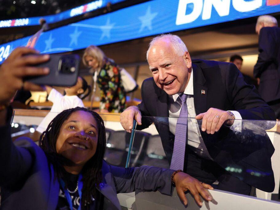 Minnesota governor and 2024 Democratic vice presidential nominee Tim Walz poses for pictures with an attendee on the first day of the Democratic National Convention at the United Center in Chicago on Monday. Walz is addressing the convention on Wednesday to accept the party's nomination.