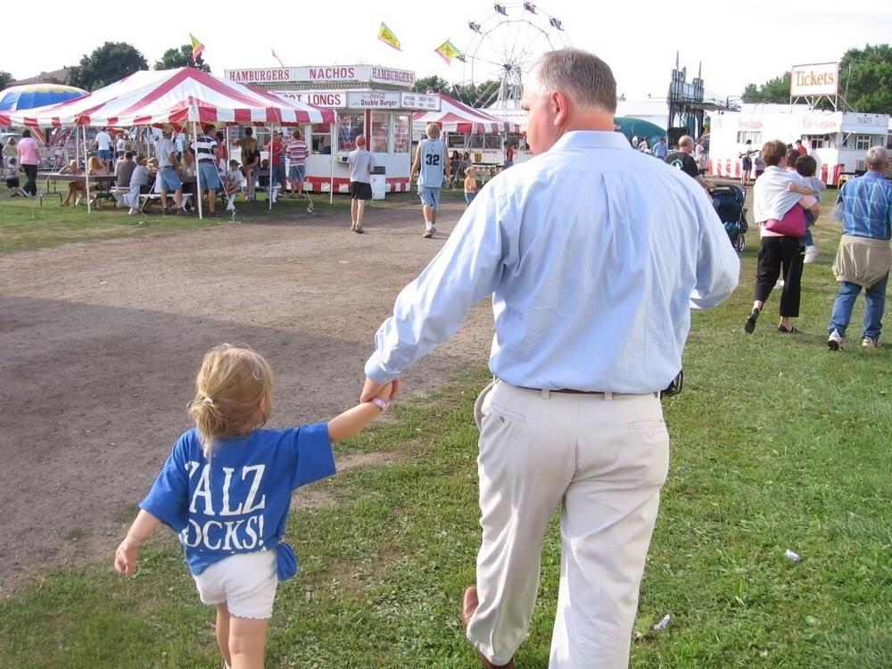  Hope Walz, left, wearing a campaign t-shirt, holds hands with her dad, Tim Walz, as he campaigned for Congress in 2005. 
