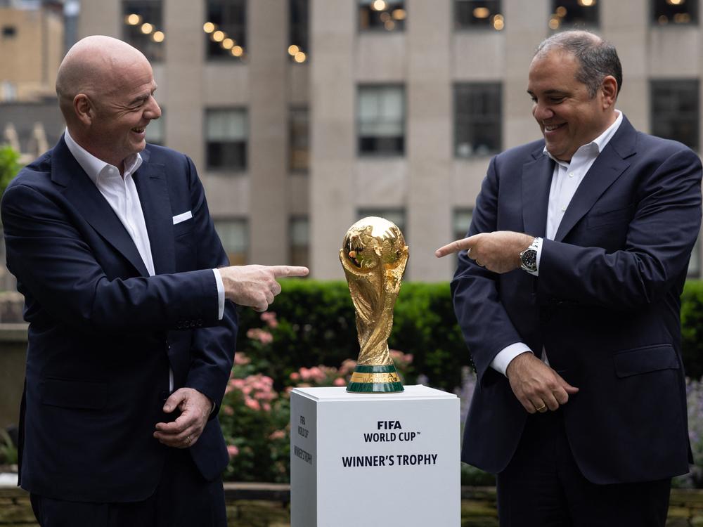 FIFA President Gianni Infantino (L) and CONCACAF President Victor Montagliani (R) pose with the FIFA World Cup trophy during an event in New York  on June 16, 2022. 