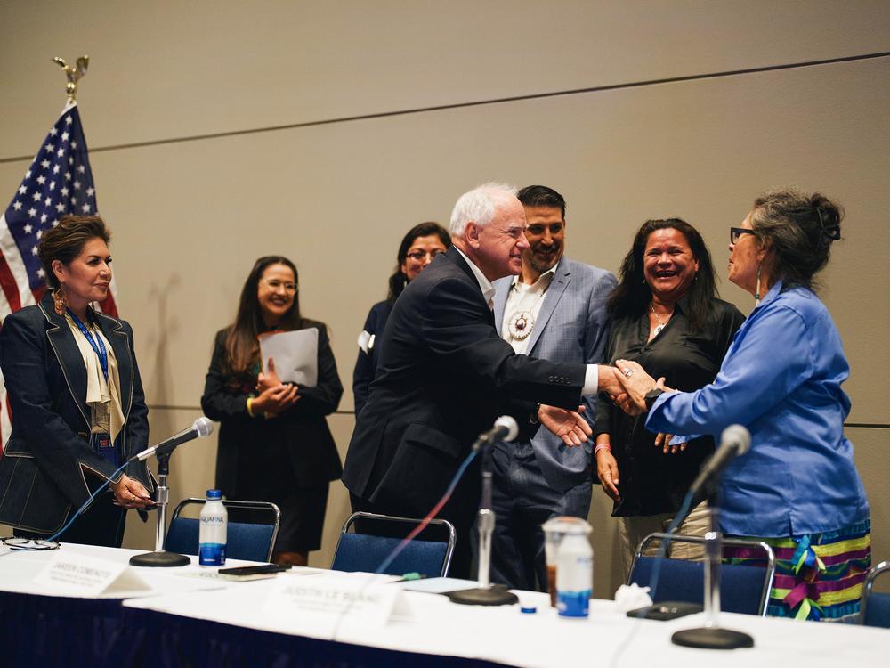 Vice Presidential candidate and Minnesota Gov. Tim Walz shakes hands with panelists during the Native American Caucus meeting at McCormick Place in Chicago on Aug. 19, 2024.