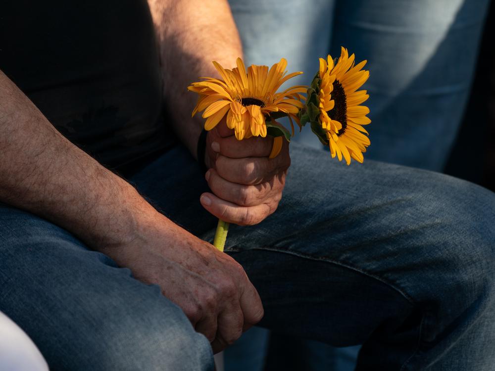 A mourner holds flowers during Munder's funeral, Aug. 22.