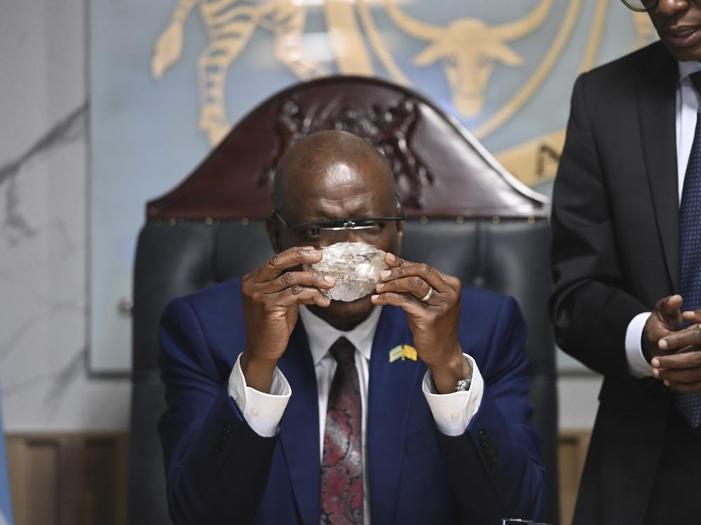 Botswana's President Mokgweetsi Masisi holds the 2,492-carat diamond that was unearthed at one of its mines and will be put on show, on Thursday, Aug. 22, 2024, in Gaborone.