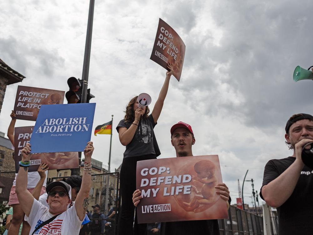 Anti-abortion protesters stand outside of the Republican National Convention in Milwaukee in July. Wisconsin reverted to an 1800s abortion ban when <em>Roe </em>was overturned. The courts have since reinstated some abortion access in Wisconsin.