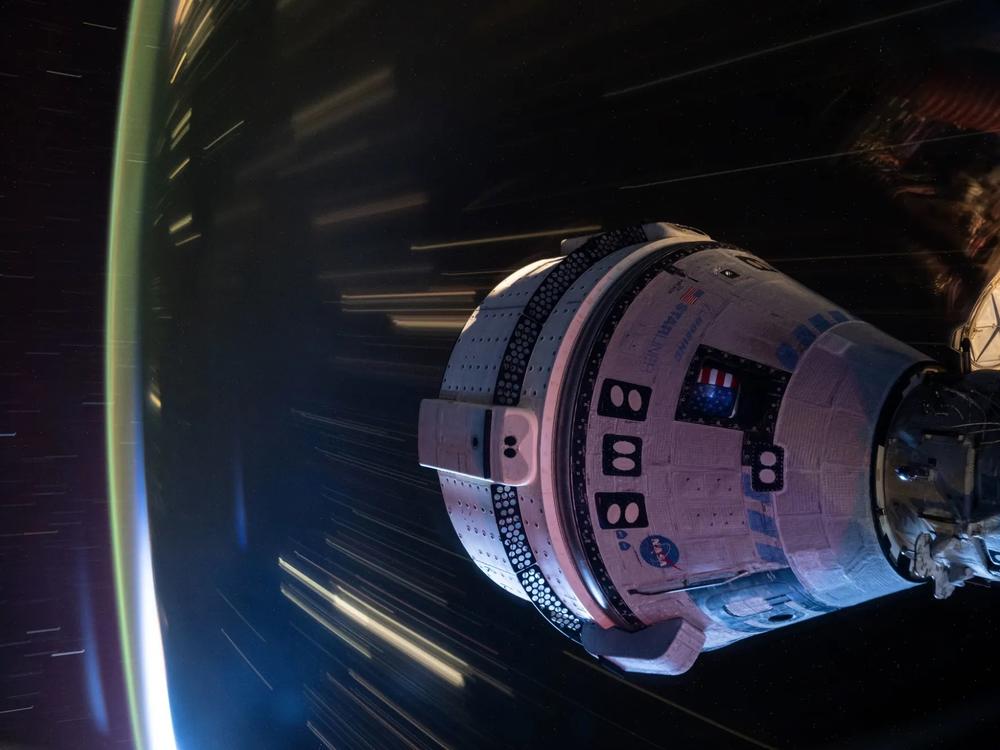This long-duration photo shows Boeing’s Starliner docked to the International Space Station at night, with the Earth whizzing by below. 