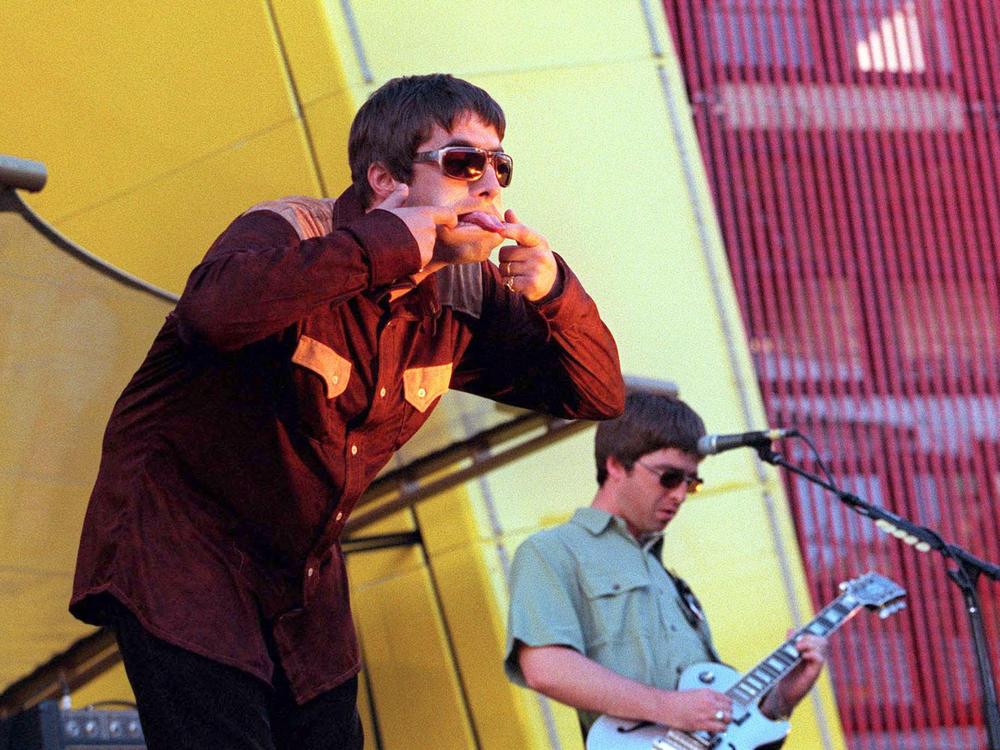 Singer Liam Gallagher (L) and brother Noel Gallagher of band Oasis perform on stage in San Francisco in 1997. After the band split, they pursued separate musical careers and continued to trade public insults.