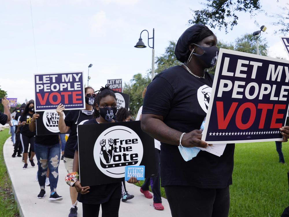 Supporters of restoring Florida felons' voting rights march to an early voting precinct on Oct. 24, 2020, in Fort Lauderdale, Fla.