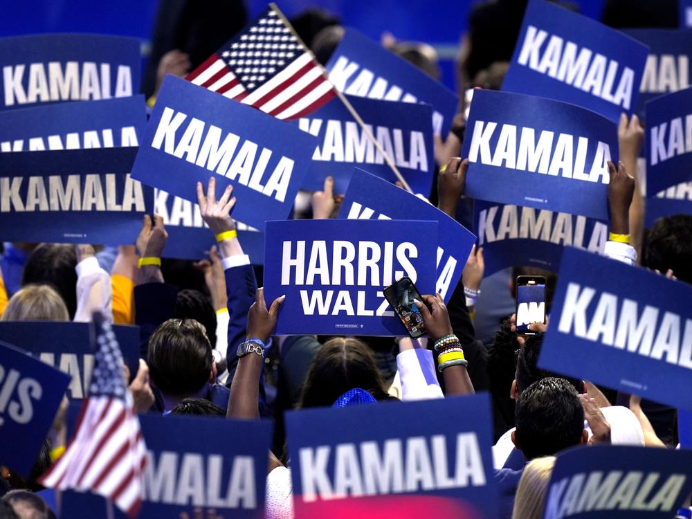 Supporters carry signs as Democratic presidential nominee Vice President Kamala Harris speaks during the Democratic National Convention on Aug. 22 in Chicago.
