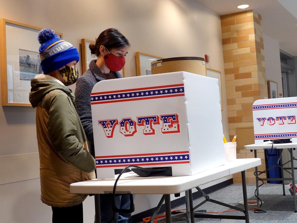 Marie Guenther votes at the Bay View Library with her son in October 2020 in Milwaukee, Wis., considered a battleground state.