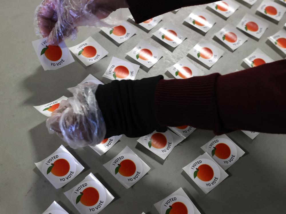 A poll worker lays out stickers at the Gwinnett County Fairgrounds in October 2020 in Lawrenceville, Ga.