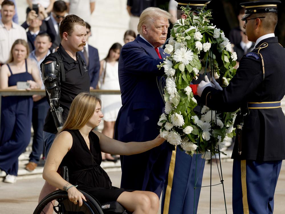 Former President Donald Trump lays a wreath alongside Marine Cpl. Kelsee Lainhart (Ret.) and U.S. Marine Corps. Sergeant Tyler Vargas-Andrews (Ret.) who were injured at the Abbey Gate Bombing, during a wreath-laying ceremony at the Tomb of the Unknown Soldier at Arlington National Cemetery on Aug. 26 in Arlington, Va.
