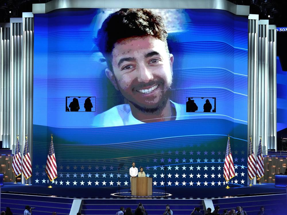 Jon Polin, left, and Rachel Goldberg, parents of Hersh Goldberg-Polin, pictured on screen speak during the Democratic National Convention on Aug. 21, 2024, in Chicago.