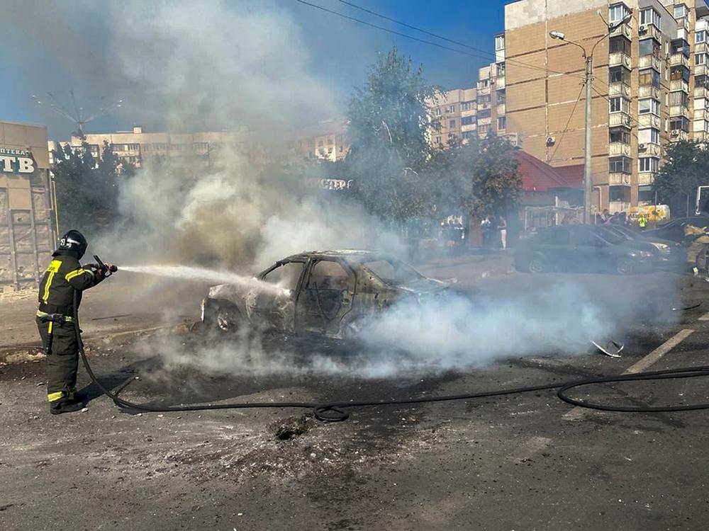 In this photo released by Belgorod regional governor Vyacheslav Gladkov's Telegram channel on Sunday, Sept. 1, 2024, firefighters extinguish a burning car in the courtyard of an apartment building after a missile attack by the Armed Forces of Ukraine on the city of Belgorod and the Belgorod region of Russia.
