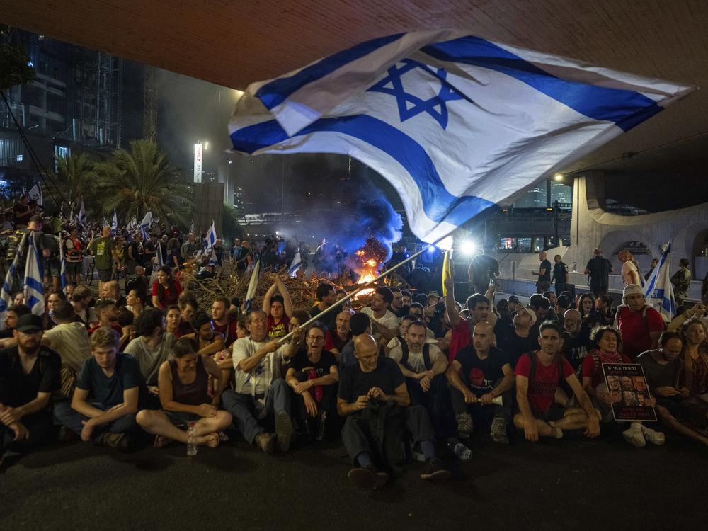 People block a road as they protest, calling for a deal for the immediate release of hostages held in the Gaza Strip by Hamas, in Tel Aviv, Israel, Sunday, Sept. 1, 2024.