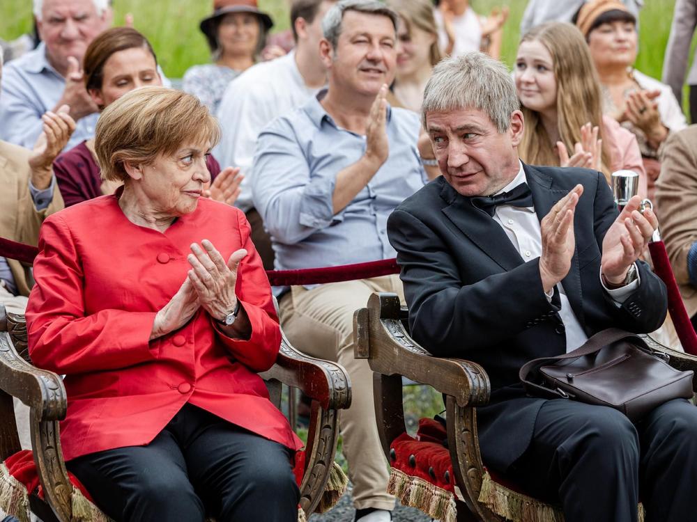 In a scene from the TV series, Miss Merkel, played by Katharina Thalbach, and her husband, played by Joachim Sauer, sit in the audience watching a play.