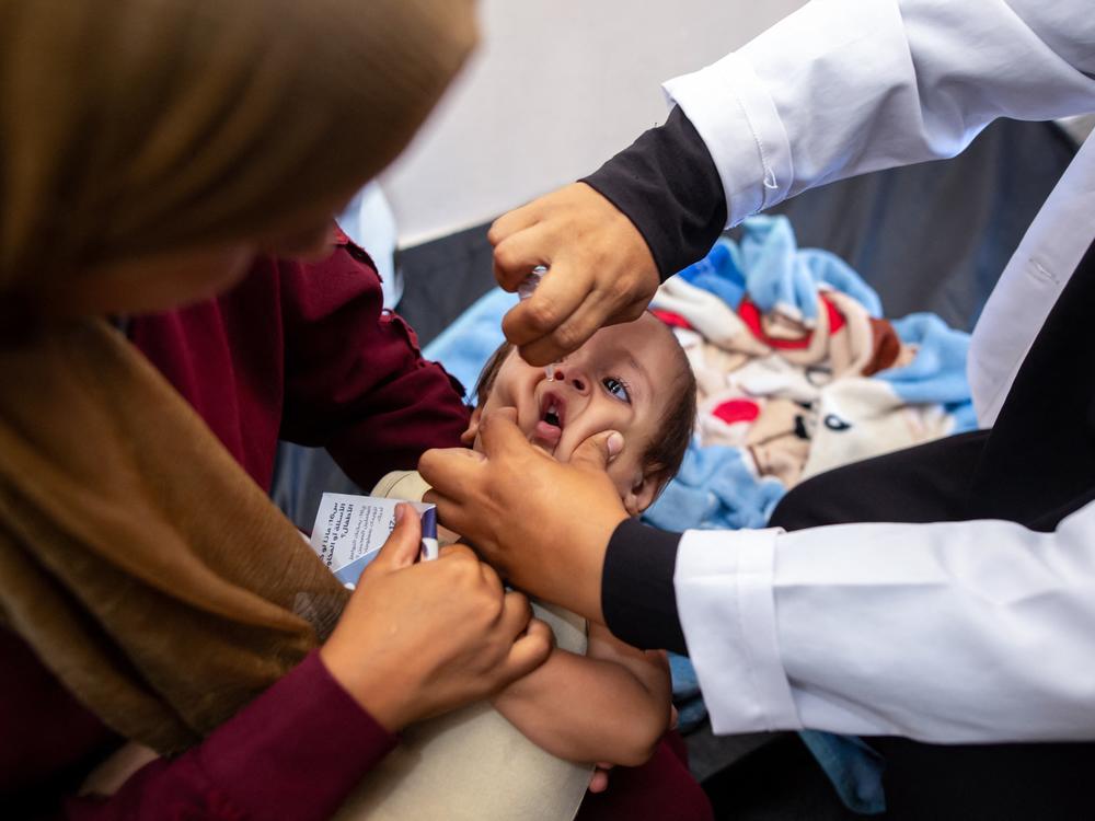 A nurse administers polio vaccine drops to a young Palestinian patient at the Nasser hospital in Khan Yunis in the southern Gaza Strip on Saturday amid the ongoing conflict between Israel and the Hamas militant group. 
