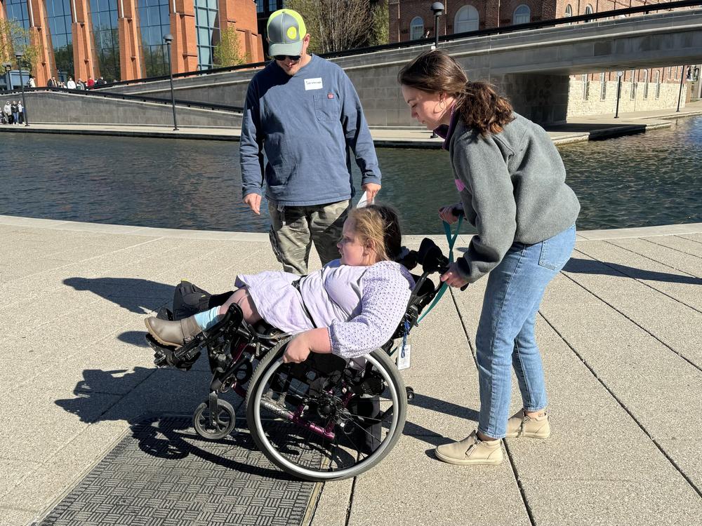  Occupational therapist and Skills on Wheels volunteer Maria Fuchs guides 12-year-old Savannah Healton through some wheelchair skills. 