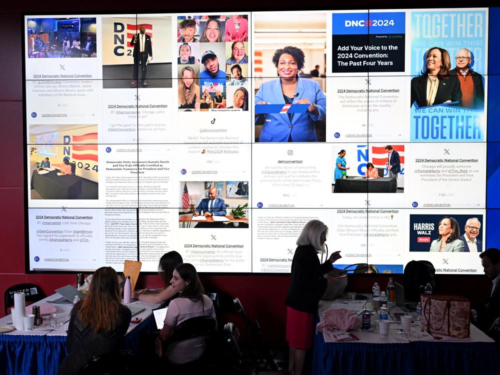People sit next to a content creators wall on the third day of the Democratic National Convention at the United Center in Chicago in August.