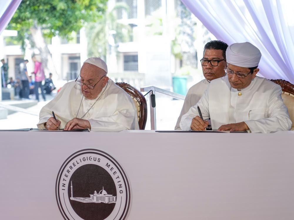 Pope Francis and the Grand Imam Nasaruddin Umar (right) sign the 