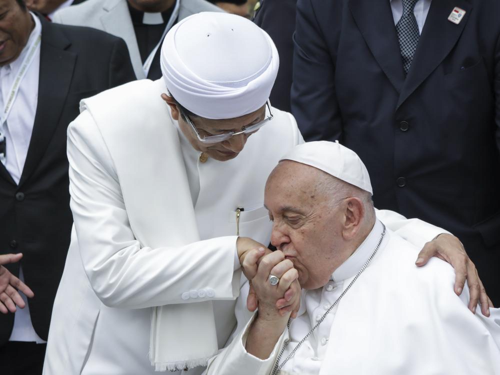 Pope Francis (right) kisses the right hand of the Grand Imam of Istiqlal Mosque Nasaruddin Umar after an interreligious meeting with faith leaders at the Istiqlal Mosque in Jakarta, Thursday.