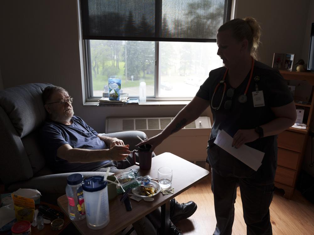 Registered nurse Susan Eback checks in on Sherwood Haakenson in his room at the Heart of America Medical Center in Rugby, N.D., on May 14. Haakenson had been suffering from multiple fainting episodes in recent months.