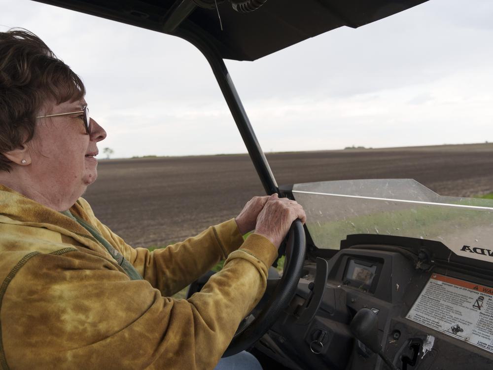Cindie Haakenson drives an ATV between her family farm and a neighboring property in Willow City, N.D., on May 21.