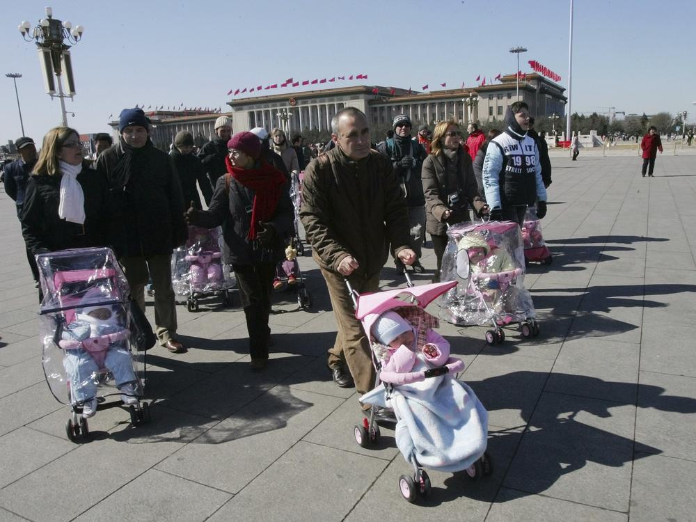 Spanish couples take their newly adopted Chinese children for a walk in Beijing's Tiananmen Square, March 7, 2007. 