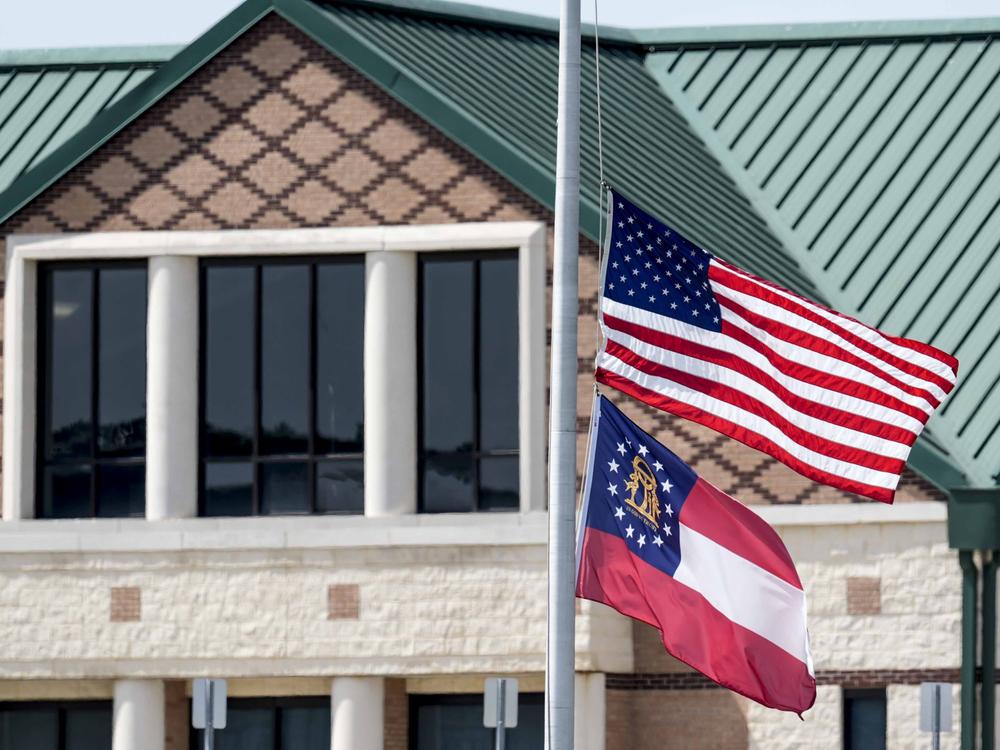 The American and state of Georgia flags fly half-staff on Thursday after a shooting at Apalachee High School in Winder, Ga.