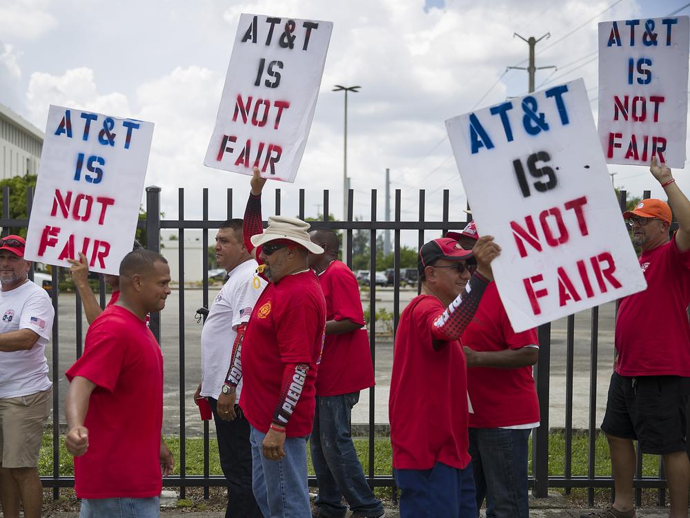 Union workers picket near the entrance to an AT&T facility in Miami, Fla. CWA members on on strike after union negotiators alleged that AT&T management engaged in unfair labor practices during contract negotiations.