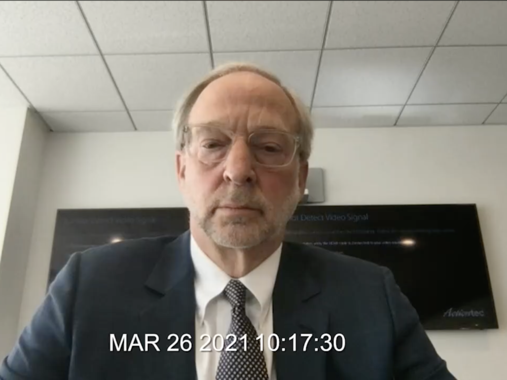A screenshot of Rick Jacobs testifying at his videotaped deposition.