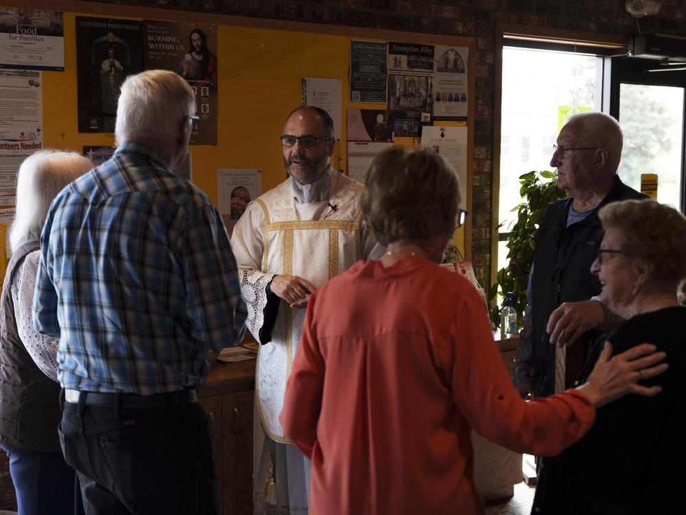 Benz greets parishioners after a Saturday afternoon Mass at the Sacred Heart Catholic Church on May 24. Benz leads three congregations in neighboring counties but says he rarely misses a home visit.