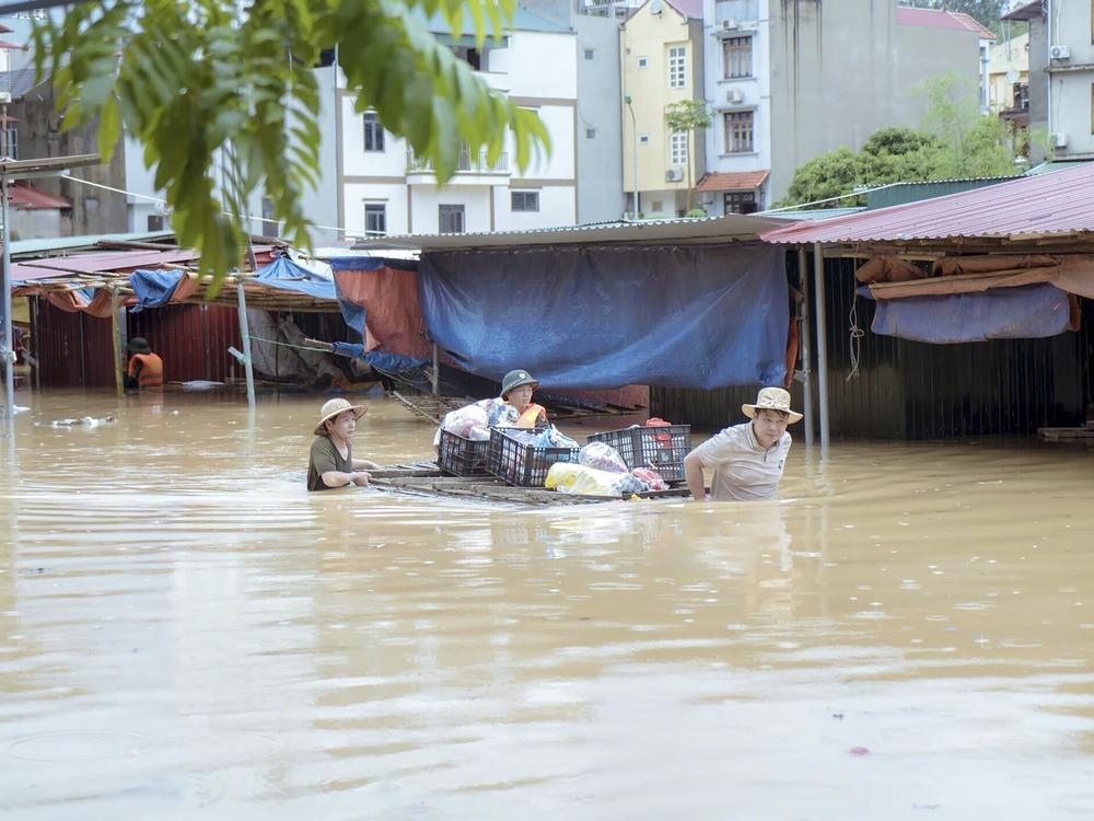 People carry belongings in flood triggered by Typhoon Yagi in Lang Son province, Vietnam, on Monday, Sept. 9, 2024.